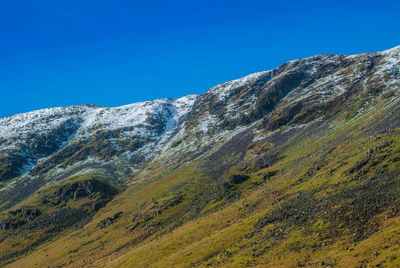 Low angle view of mountain against blue sky