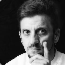 Close-up portrait of man against black background