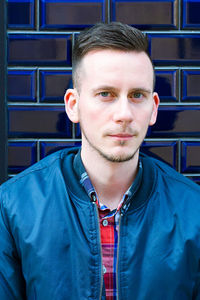 Portrait of young man against tiled wall