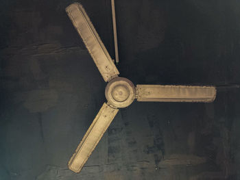 Low angle view of electric fan on wall