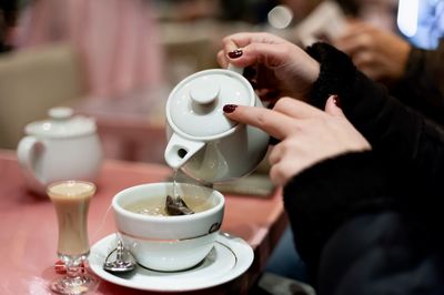 Midsection of man holding coffee cup on table