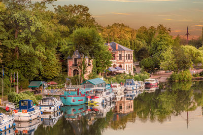 Houses by lake and buildings against sky