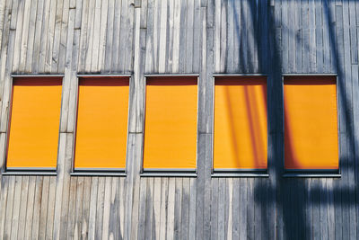 Full frame shot of wall with orange window blinds