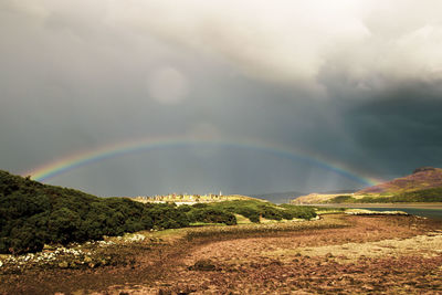 Scenic view of rainbow over landscape against sky