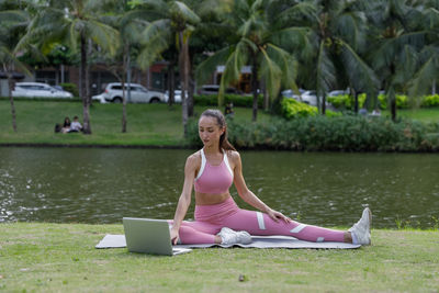 Portrait of young woman sitting on lake