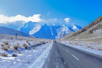 Road between snow covered mountains against the sky. 