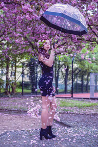 Full length of woman standing on wet tree