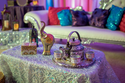 Close-up of figurines and antique crockery on coffee table during wedding