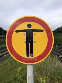 Close-up of road sign against sky