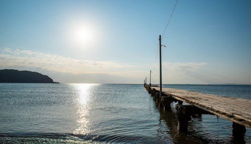 Jetty over river against sky