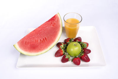 Close-up of fruits in plate against white background