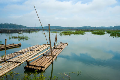Traditional bamboo pier on lake against sky