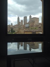 Modern buildings against cloudy sky