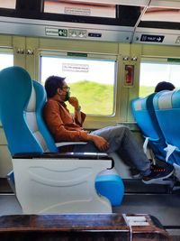 Rear view of woman sitting in train
