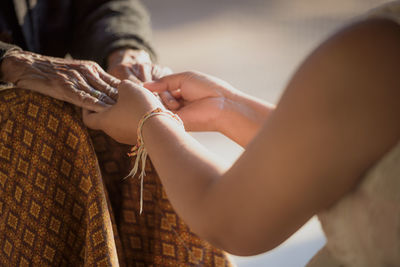 Midsection of couple holding hands