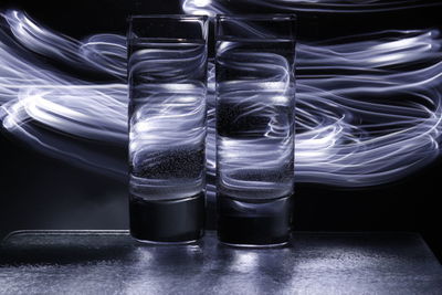 Close-up of glasses on table against black background