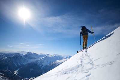 Ski touring uphill with a mountain backdrop