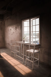 Empty chairs and table in abandoned building