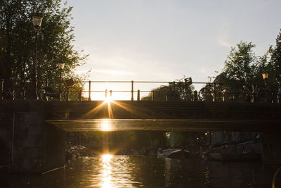 Low angle view of silhouette bridge over river against sky during sunset