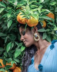 Portrait of young woman with green leaves