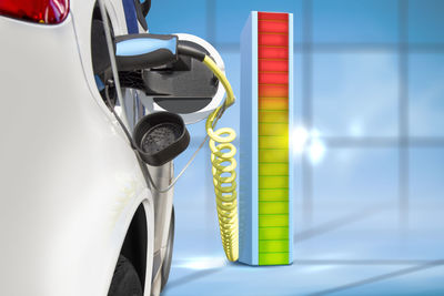 Digital composite image of car charging with battery