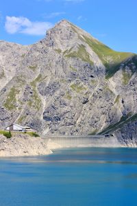 Scenic view of lake and mountains against blue sky