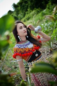 Close-up of woman wearing traditional clothes while standing amidst plants