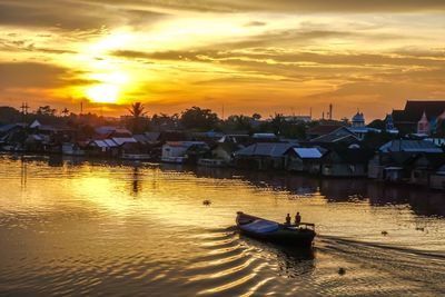 Boats moored at shore against sky during sunset