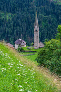 Built structure on field by buildings against trees