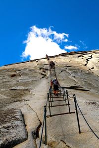 Low angle view of people climbing mountain