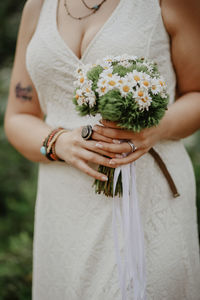 Midsection of woman holding flower bouquet