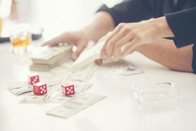 Midsection of businessman with dice and money on table