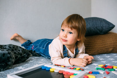 Child plays at home an educational game with a multi-colored magnetic puzzle