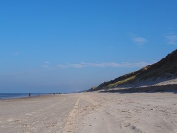 Scenic view of beach against blue sky