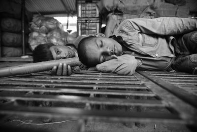 Surface level of boys lying on metal grate