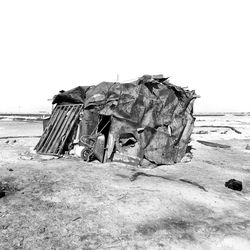 Damaged boat on beach against clear sky