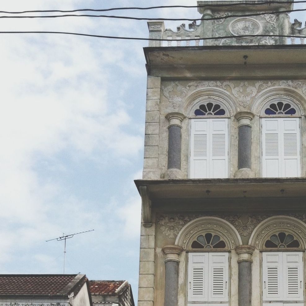 architecture, built structure, building exterior, low angle view, sky, day, communication, window, no people, building, text, outdoors, cloud - sky, old, city, clock, street light, western script, cloud, power line