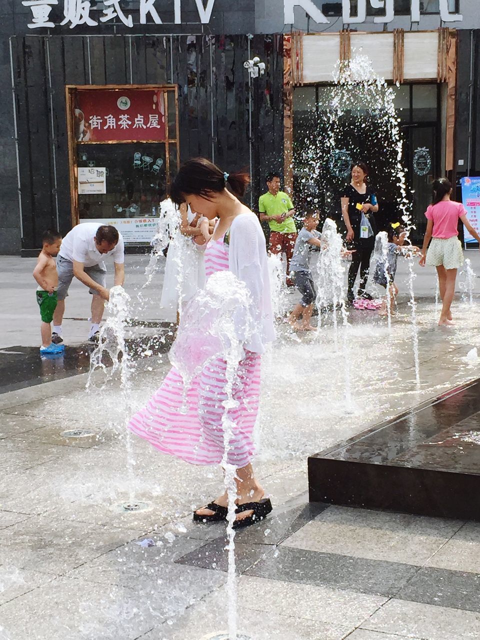 water, fountain, motion, lifestyles, spraying, splashing, leisure activity, full length, men, built structure, person, incidental people, long exposure, outdoors, architecture, creativity, rear view, day