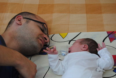 Father and son sleeping on bed at home