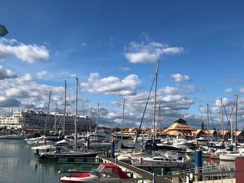 Sailboats moored at harbor