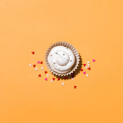 High angle view of cupcakes against orange background