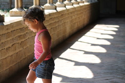 Girl walking in corridor on sunny day