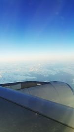 View of airplane wing over clouds