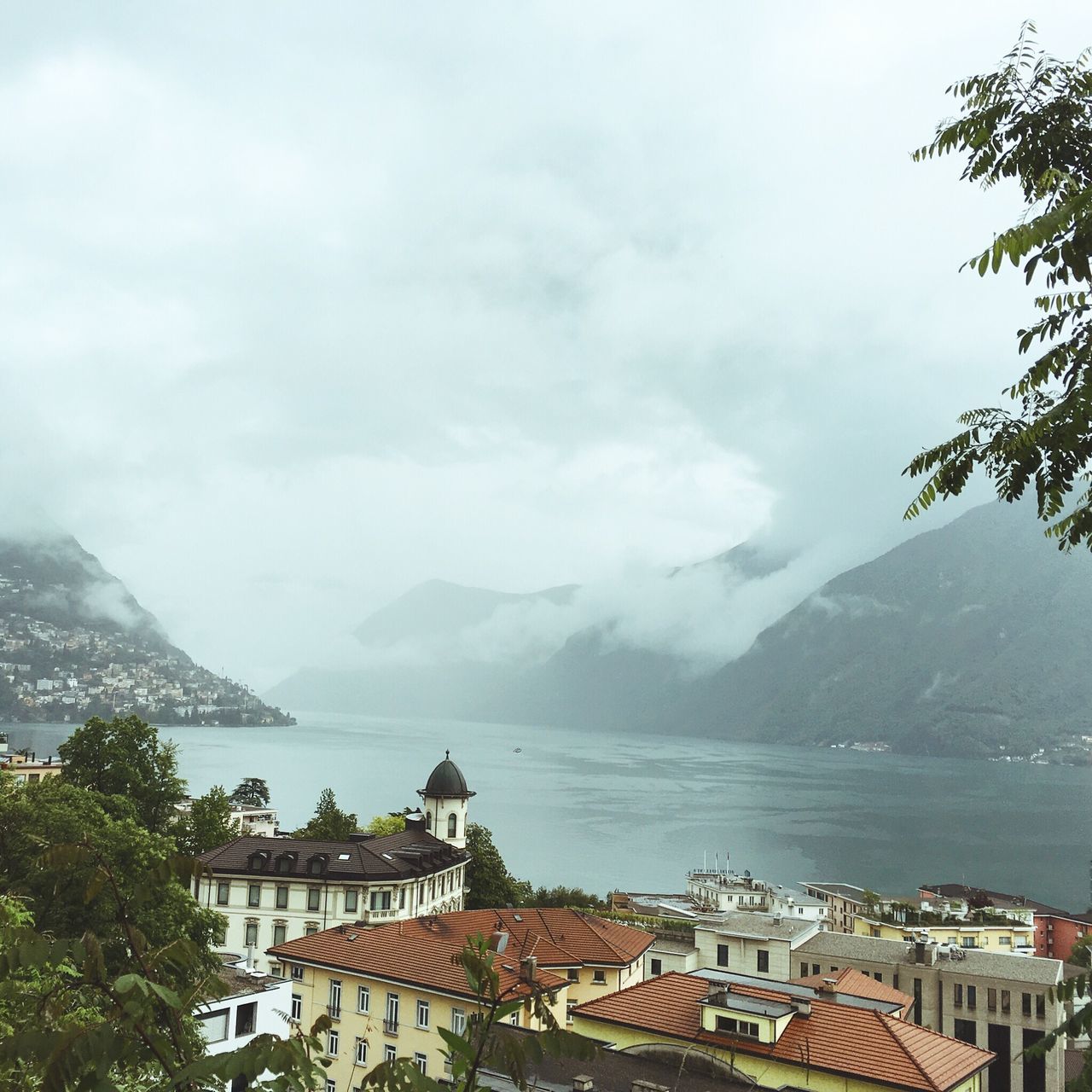 building exterior, architecture, built structure, mountain, sky, house, water, residential structure, mountain range, cloud - sky, town, residential building, residential district, tree, townscape, scenics, cloudy, sea, nature, high angle view