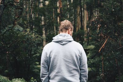 Rear view of man standing in forest