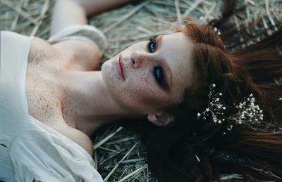 Close-up portrait of young woman lying down