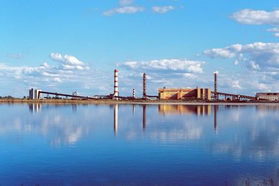 View of factory by building against sky