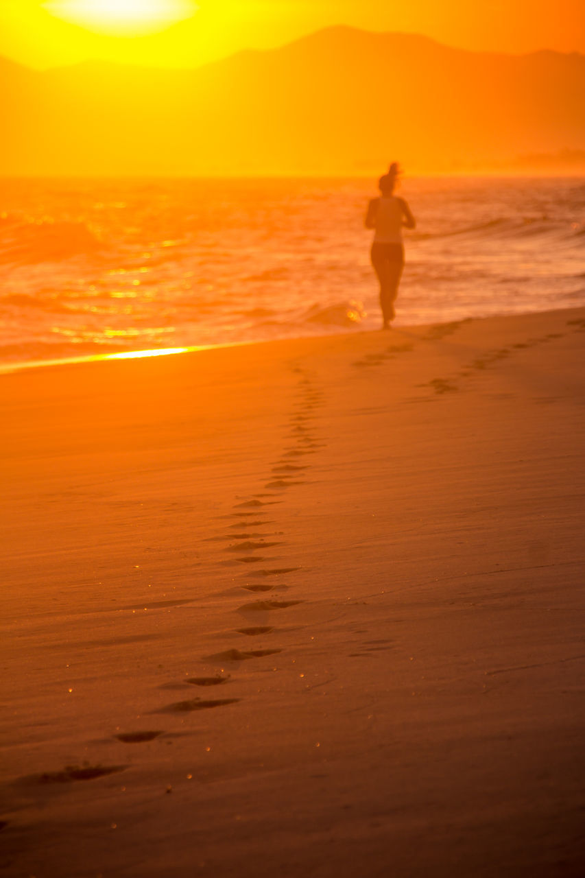 SILHOUETTE BOY ON BEACH AGAINST SKY DURING SUNSET