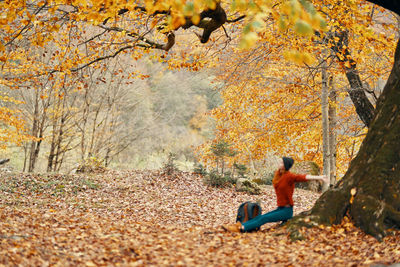 Man sitting in forest during autumn