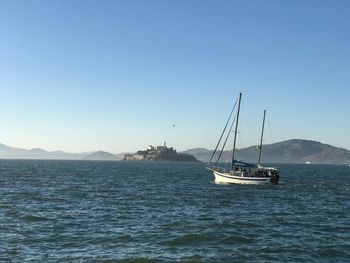 Sailboat sailing on sea against clear sky